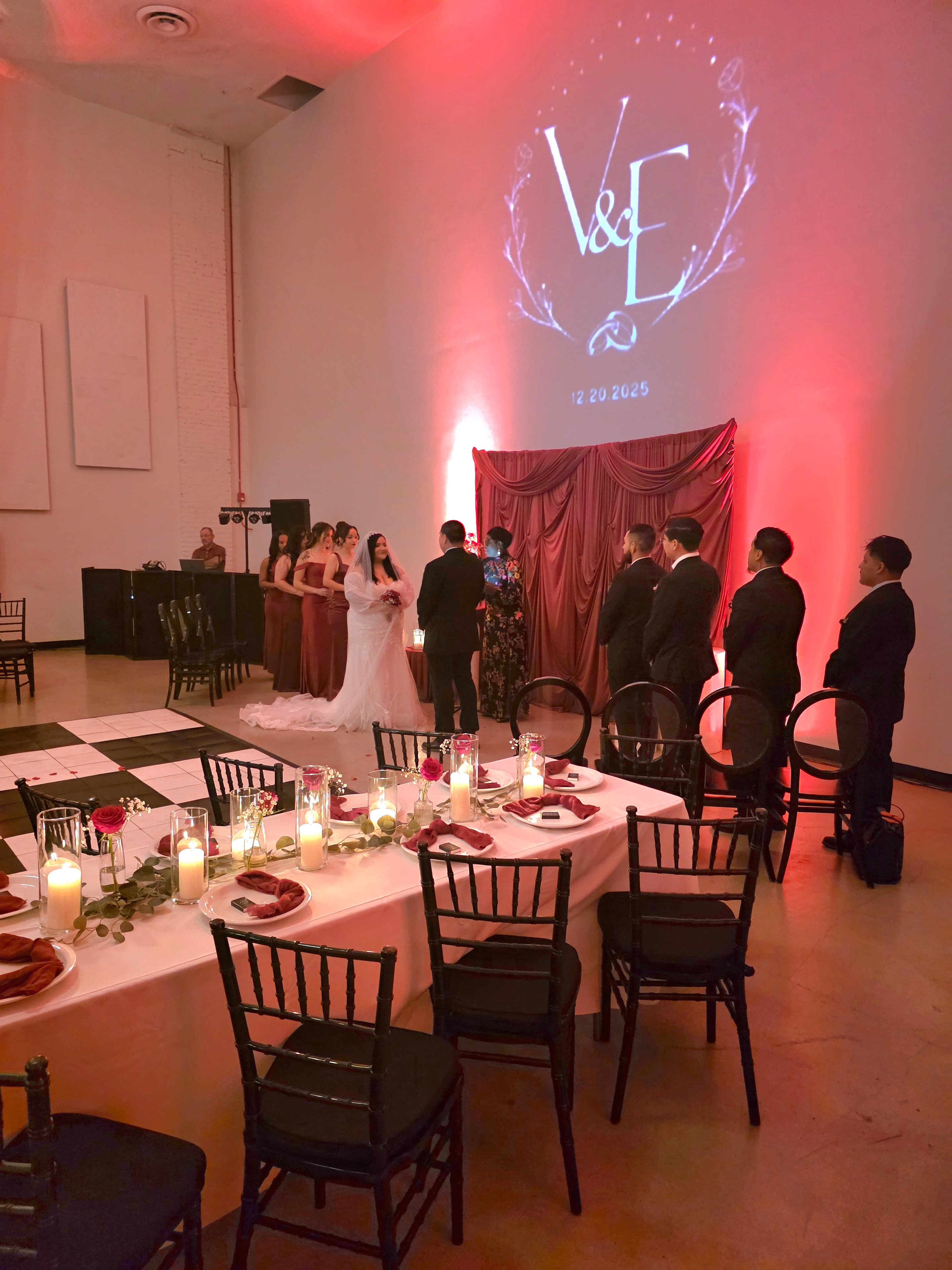 Wedding ceremony with monogram projection and red uplighting at DJ event