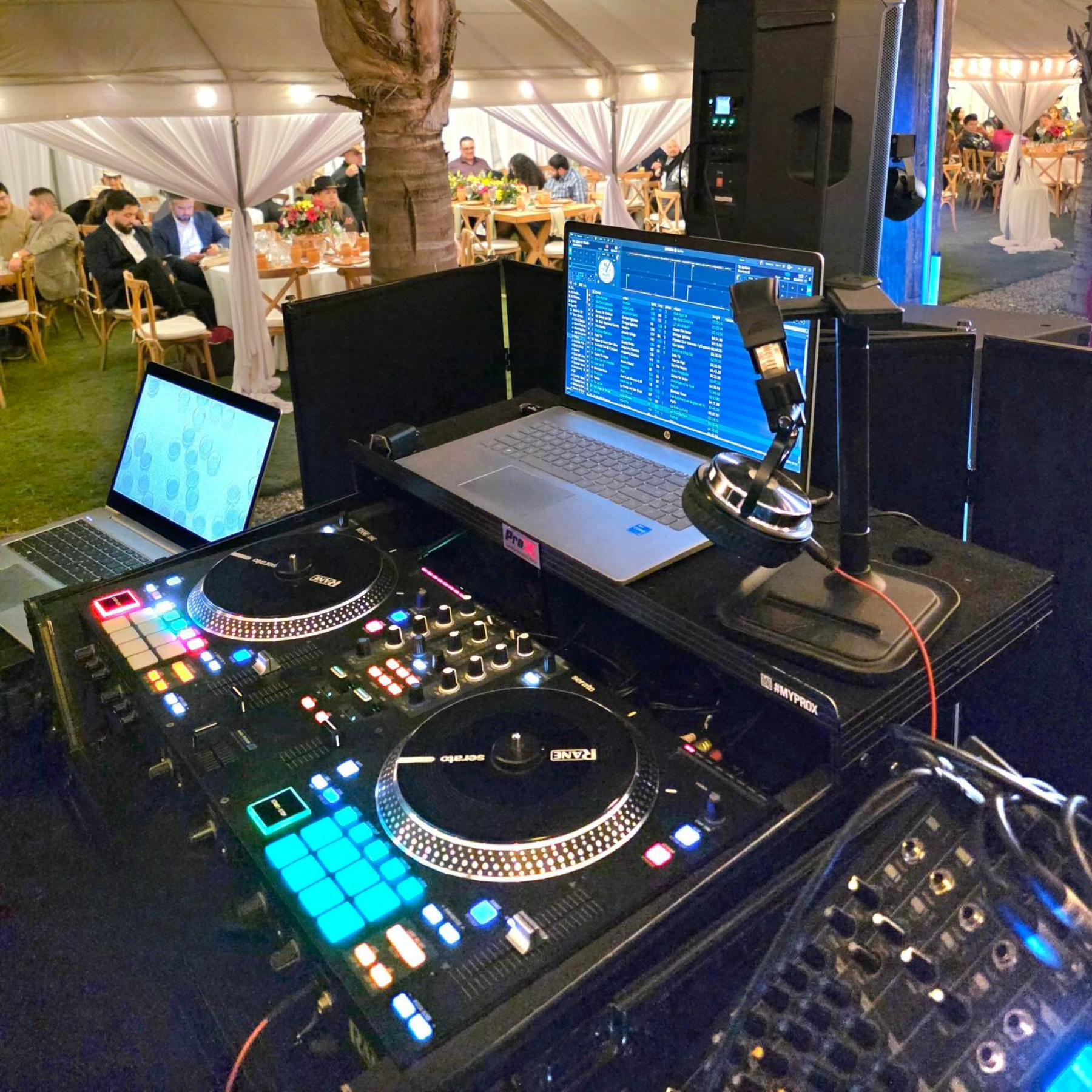 Professional DJ setup with Rane controller and laptops at outdoor wedding reception